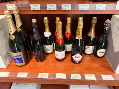 de nombreuses bouteilles de vin sur une étagère dans un magasin