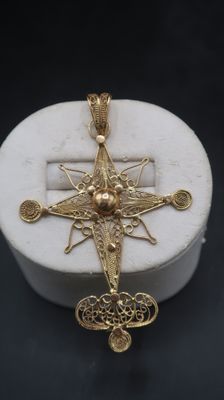 an image of a gold cross on a white marble box