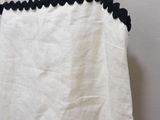 a picture of a white top with black scallops on it