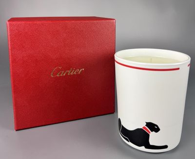 un gros plan d'une tasse ornée d'un chat, à côté d'une boîte