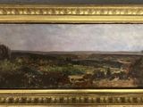 une peinture à l'huile représentant un paysage, dans un cadre doré, accrochée au mur
