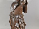 a small statue of a man holding a pipe
