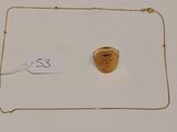 un gros plan d'un collier en or orné d'un visage