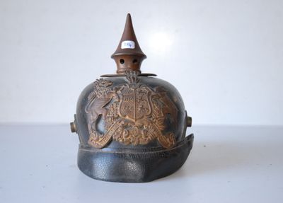 an old bell with a bird on it sitting on top of a table
