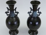 two vases that are sitting on a table