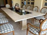 a dining room table with chairs and a table with a wine bottle on it