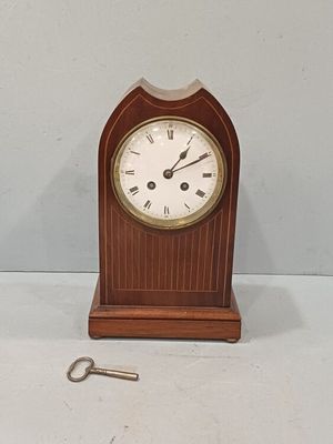 une petite horloge en bois à laquelle est attachée une clé