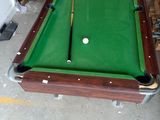 une table de billard sur laquelle se trouve une boule de billard