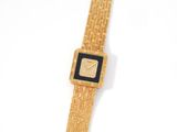 an image of a gold watch with a black face on a white surface