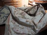 un lit recouvert d'une couverture, à côté d'une commode