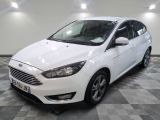 La Ford Focus blanche est garée dans une grande pièce.