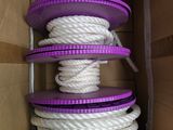 une corde violette et blanche dans une boîte en carton avec un couvercle violet