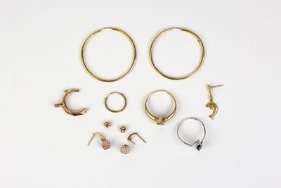 several pairs of gold and silver hoop earrings on a white surface