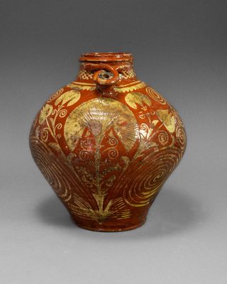 an image of a red and gold vase on a gray background