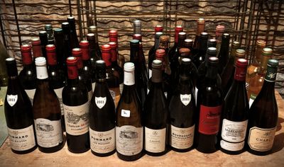 bottles of wine are lined up on a table in front of a stone wall
