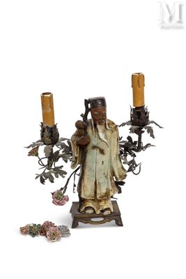 une figurine représentant un homme tenant deux bougies
