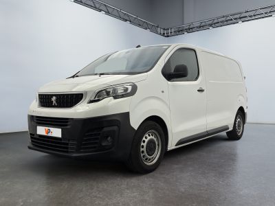 La camionnette blanche est garée à l'intérieur d'une grande pièce.