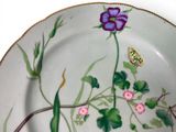 a plate with flowers and a butterfly painted on it