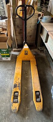 un chariot élévateur rangé dans un garage avec d'autres outils