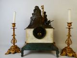 trois bougies et une horloge surmontée d'une statue