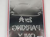 a silver parking only sign on a white table