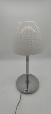 un gros plan d'une lampe de table posée sur une surface blanche