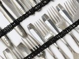 a lot of forks and spoons on a table