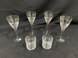 six verres à vin transparents posés les uns à côté des autres sur un fond noir
