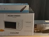trois micro-ondes sont empilés les uns sur les autres sur une table