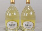 two bottles of wine sitting on top of a table next to each other
