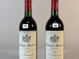 deux bouteilles de vin posées sur une table l'une à côté de l'autre