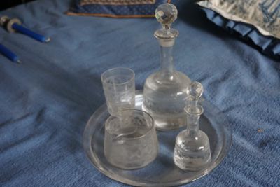 un verre posé sur un plateau, lui-même posé sur un lit