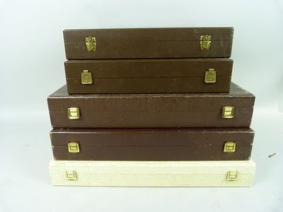 three brown suitcases stacked on top of each other on a white surface