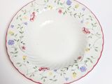 a white plate with colorful flowers on it on a table