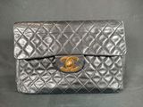 a close up of a chanel bag on a black background