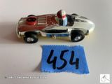 une petite voiture miniature sur laquelle est accrochée une étiquette de prix