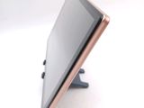 a tablet computer sitting on a stand on a white surface