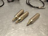 three bullet shaped pens sitting on a table next to a pair of scissors