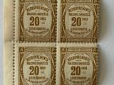 quatre vieux timbres-poste collés sur un morceau de papier posé sur une surface blanche