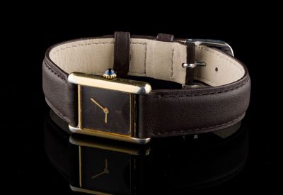 un gros plan d'une montre avec un bracelet en cuir marron