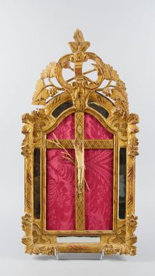 un cadre doré richement décoré sur lequel est représenté un crucifix