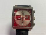 someone is holding a watch with a red face and a black strap