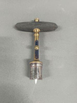 an image of a small metal object with a wooden handle