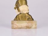 statue of a man with a mask on his head sitting on a marble block