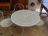 une photo d'une table et de chaises blanches dans une cuisine