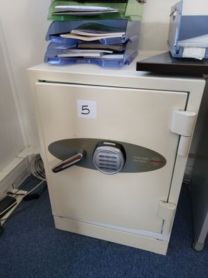 a small safe box with a bunch of files on top of it