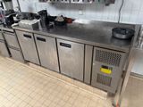 une cuisine avec des plans de travail et des placards en inox