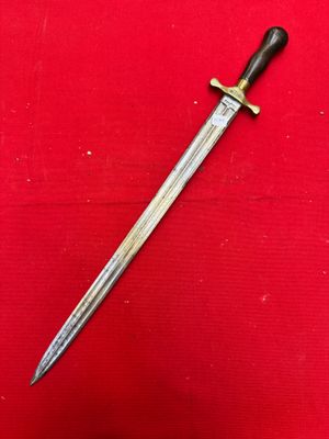 an old dagger with a wooden handle on a red surface