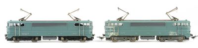 two green trains sitting side by side on a white surface