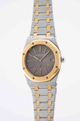 an image of a silver and gold wrist watch with a black face